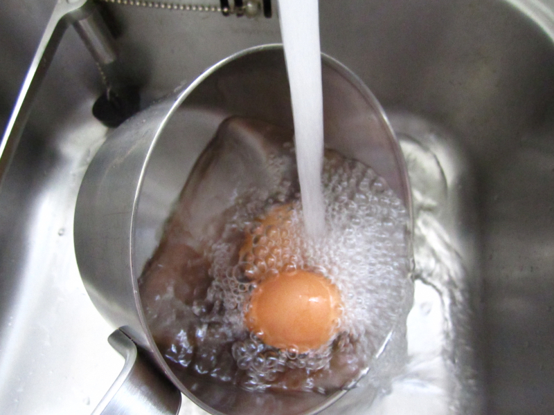 Pan met eieren onder stromend water
